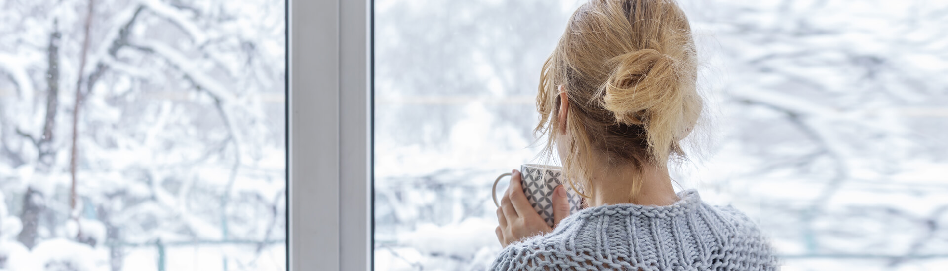 woman looking out window in winter